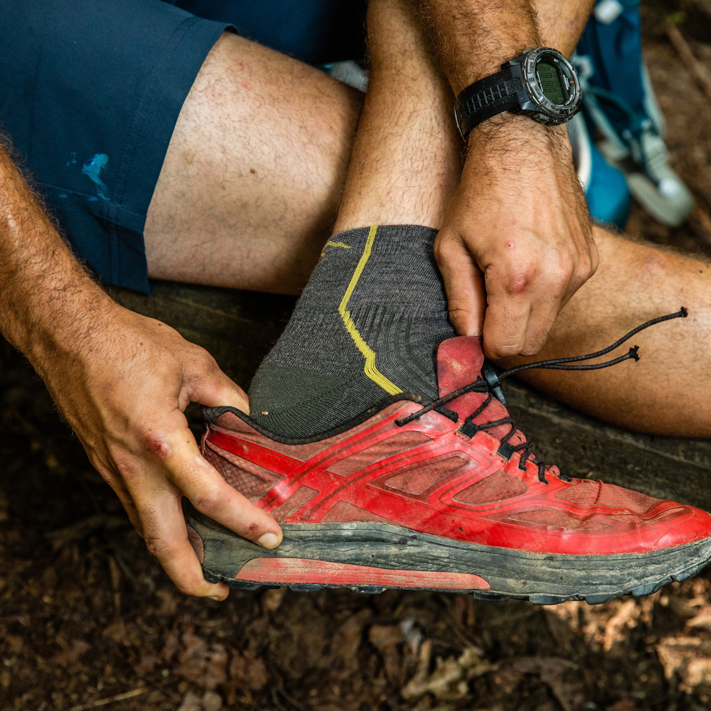 Closeup of hiker taking off hiking shoes to show his quarter hiking socks in taupe brown