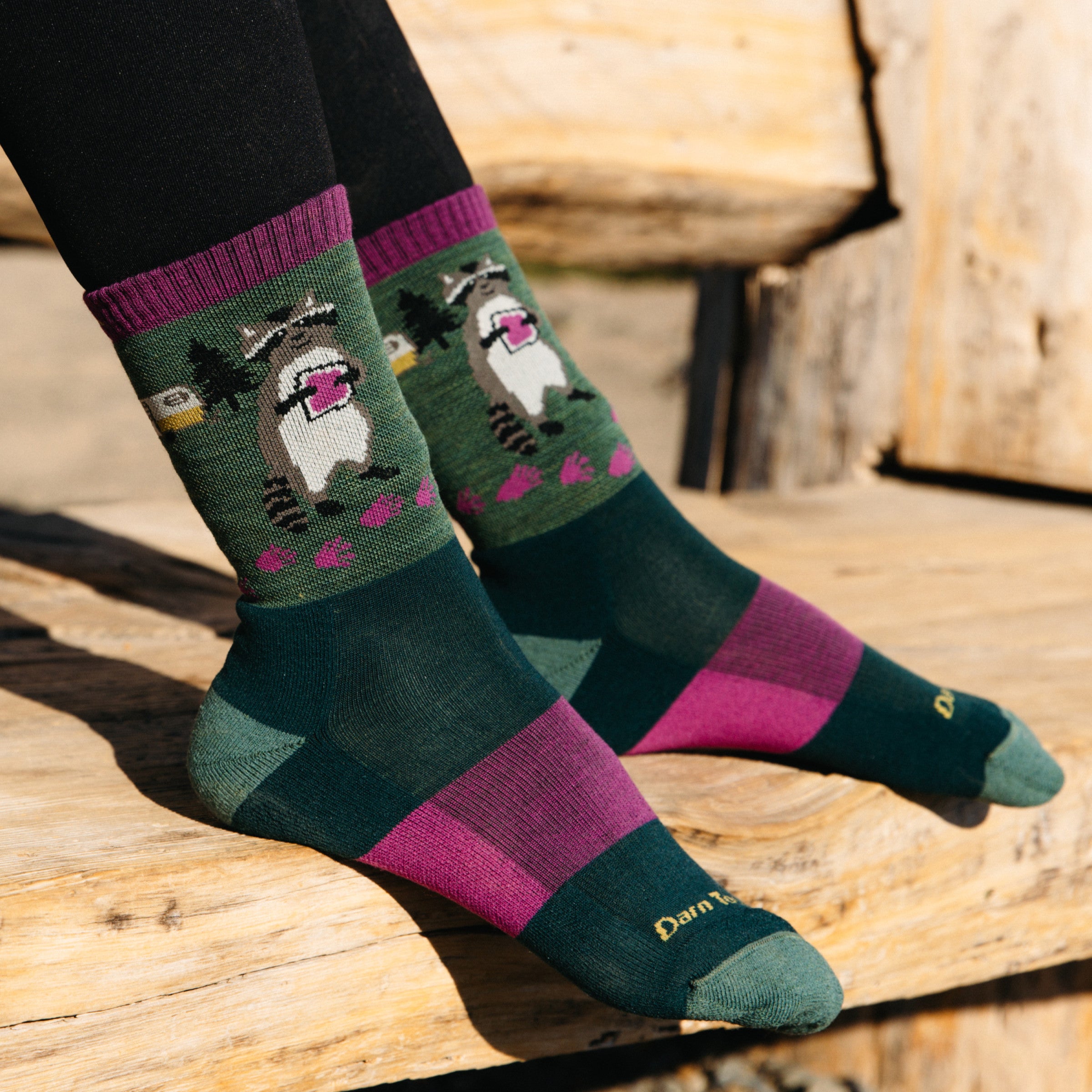 On model Image of the 5001 Critter club in Moss with feet rest on wooden bench