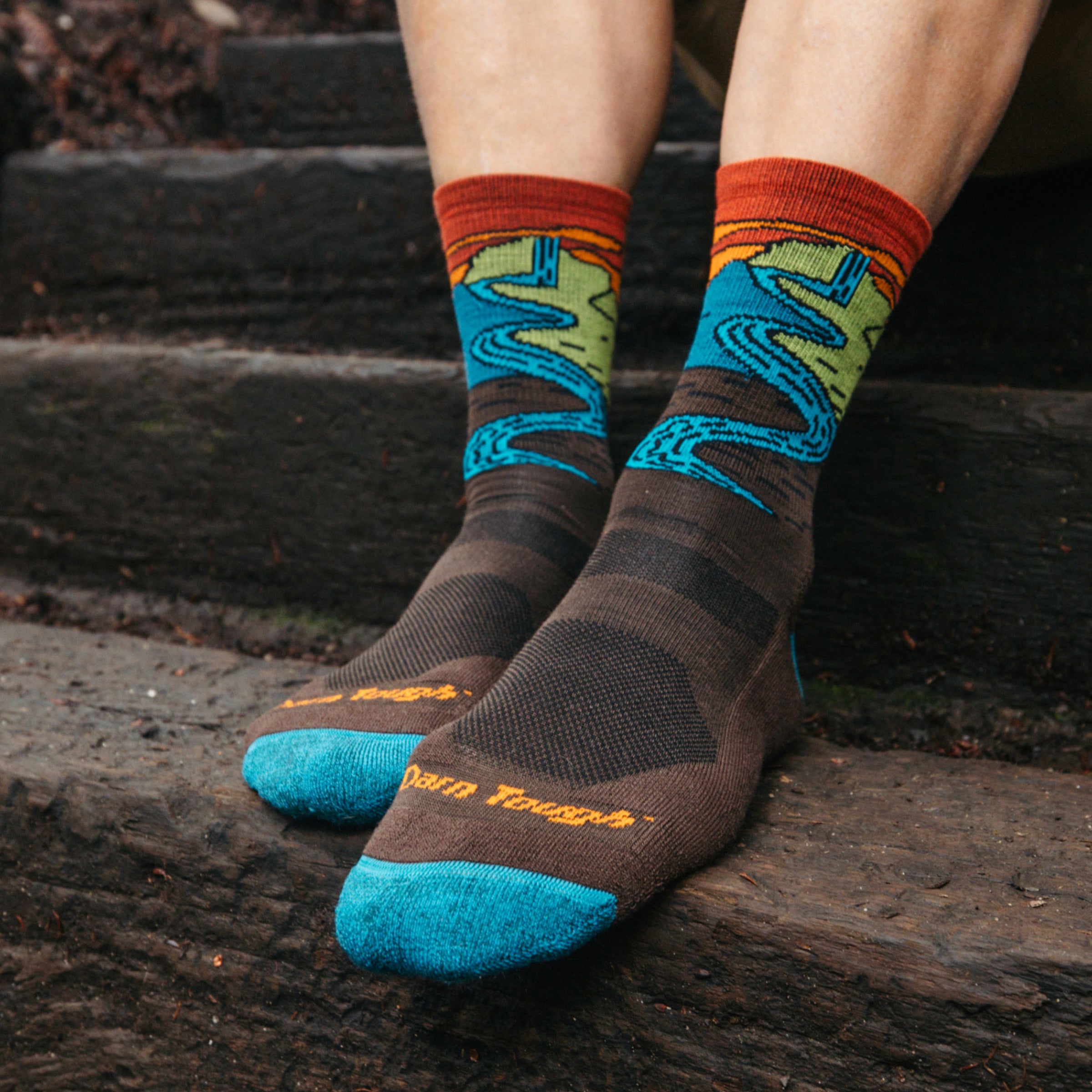 Models feet on wooden step wearing the 5020 chasing waterfalls micro crew hiking sock in Earth