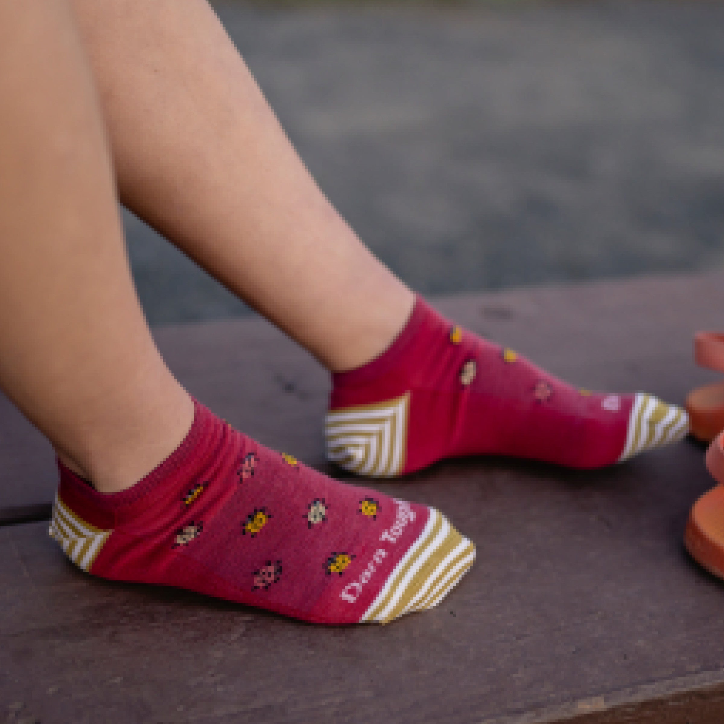Close up shot of model wearing 6074 socks in cranberry colorway without shoes