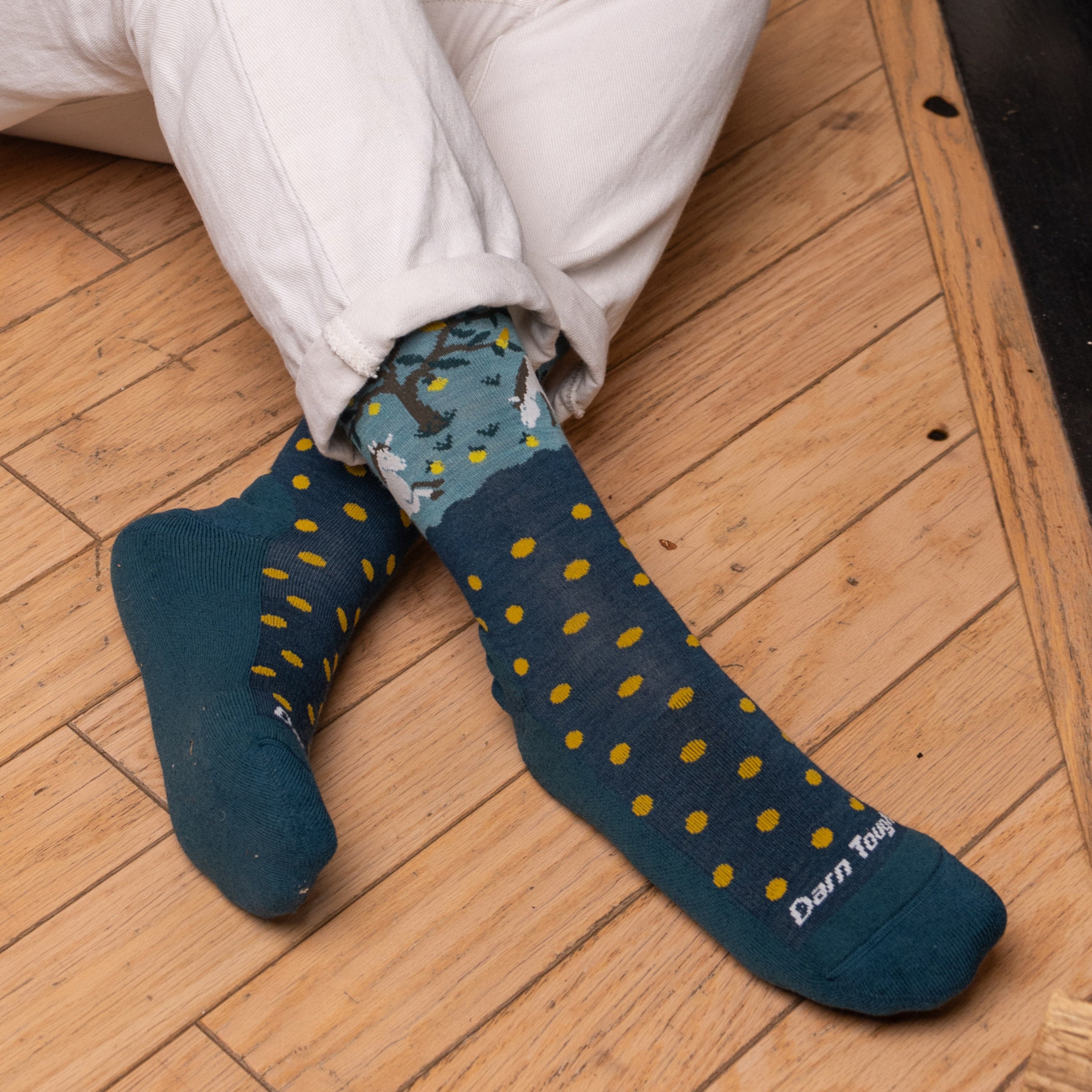 Close up on model feet on  floor wearing the 6105 Dark teal featuring dark teal body yellow polka dot on foot and Unicorn image on cuff