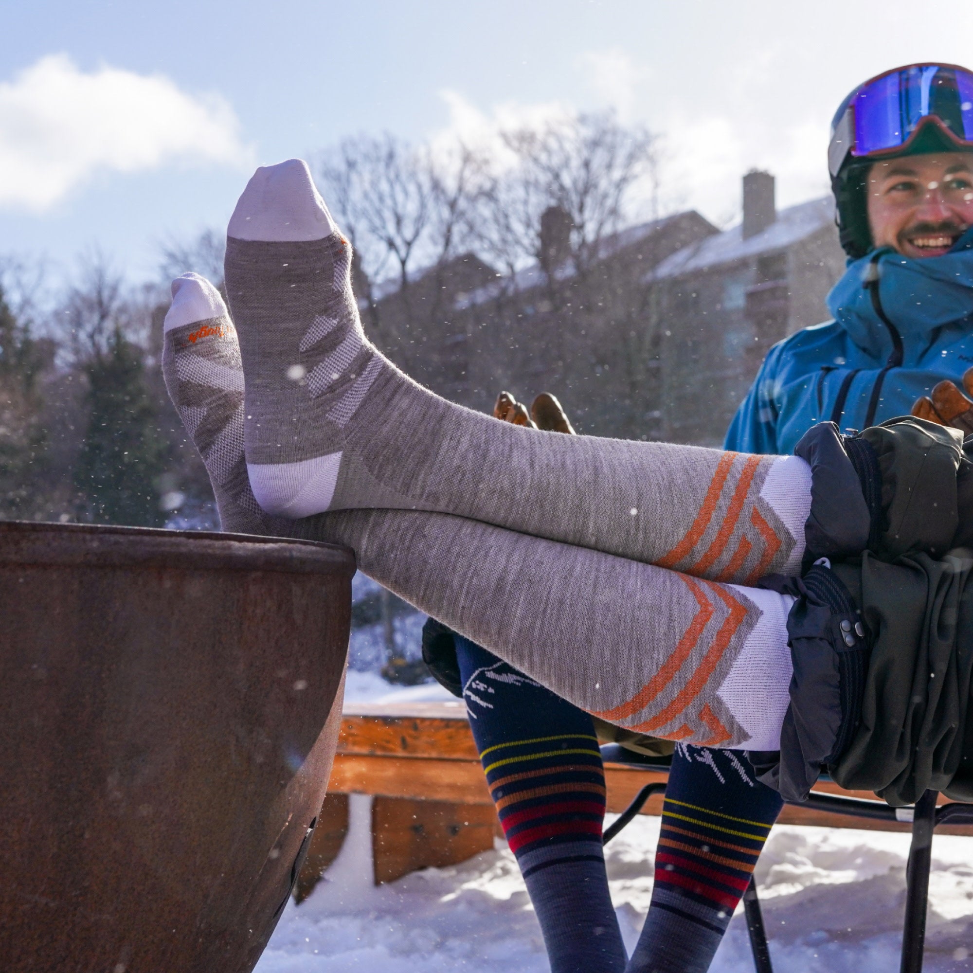model sitting outside in snow with feet up featuring the 8035 peaks RFl in biscotti