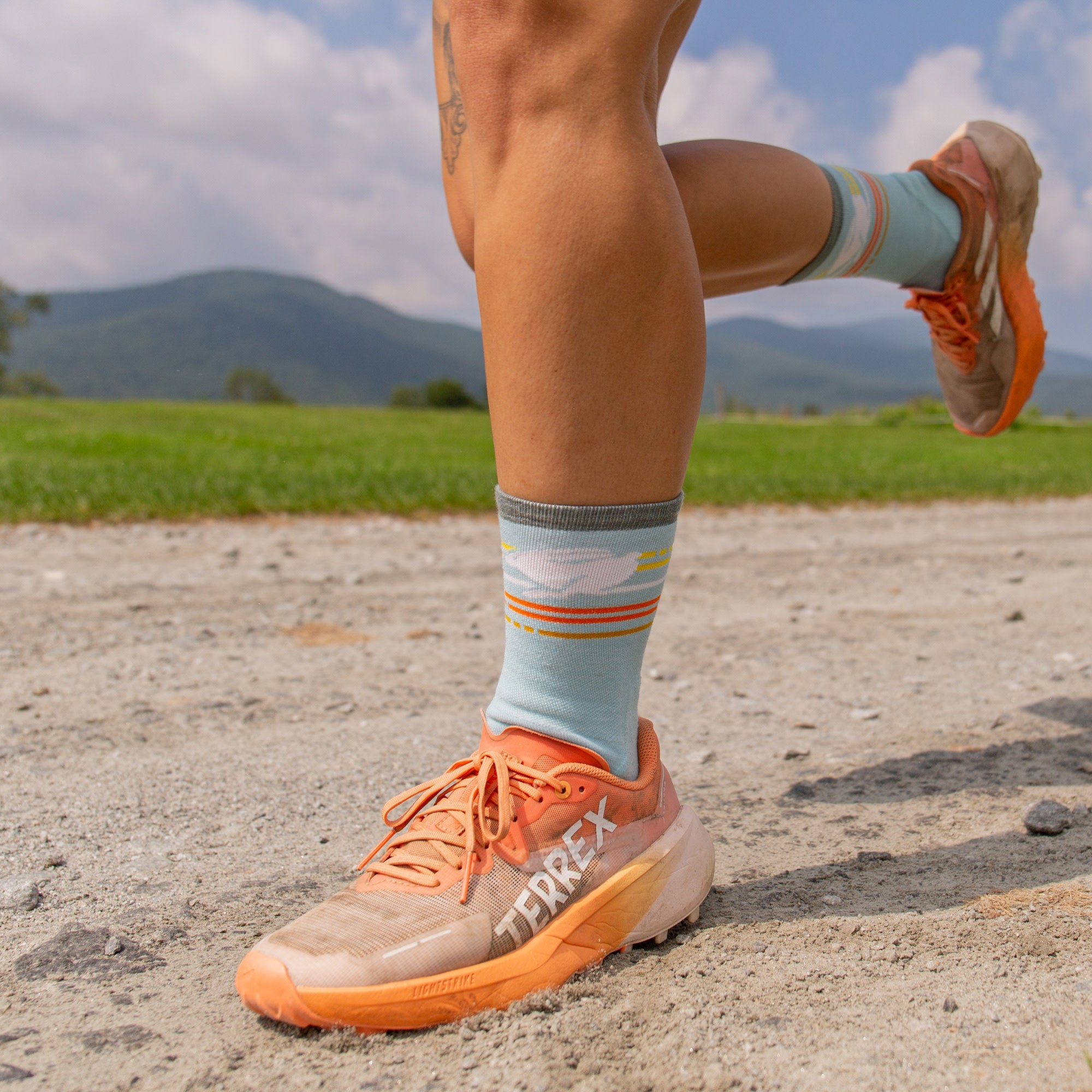 model running on dirt wearing the 1050 pacer micro crew in glacier featuring a blue body and white rabbit