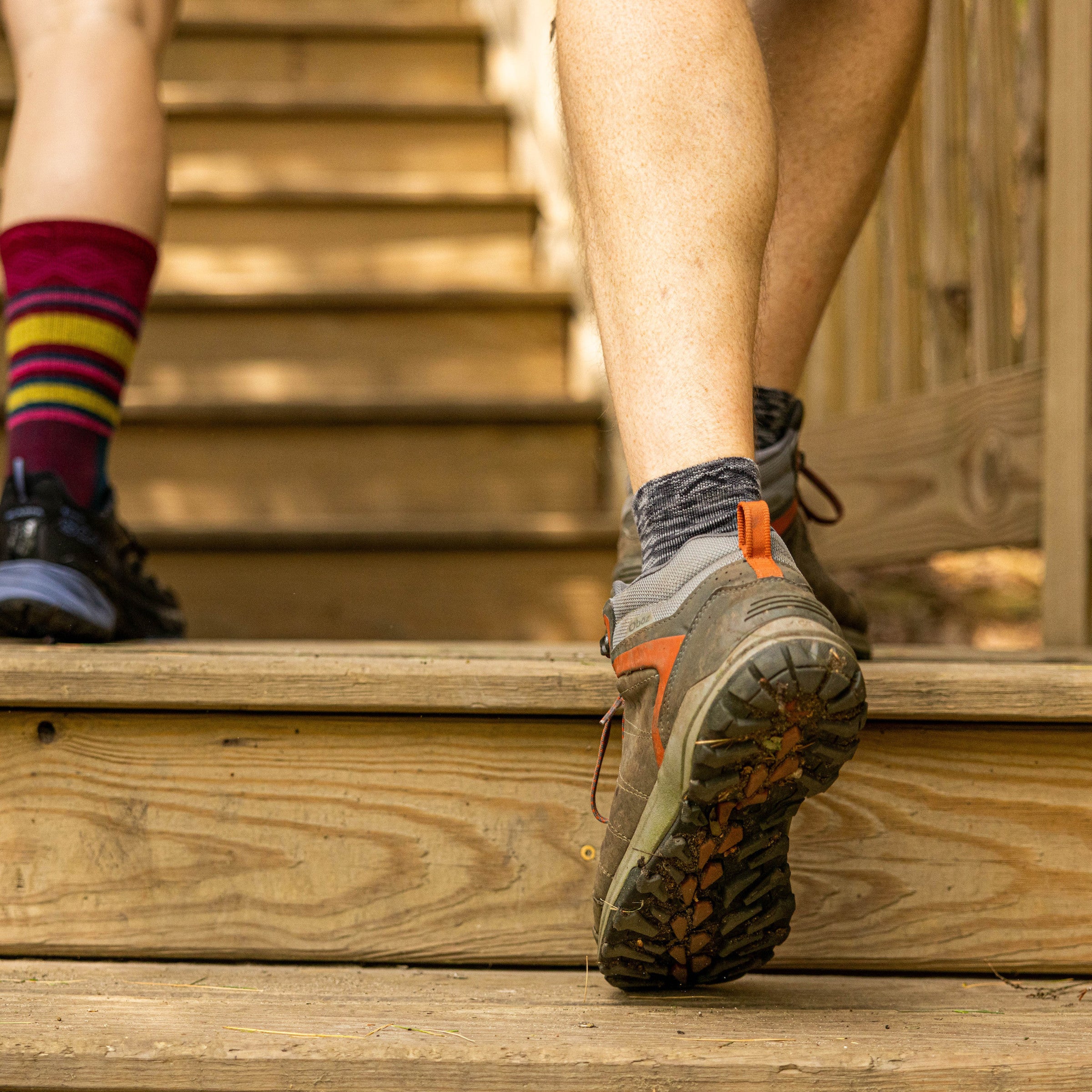 Close up shot of model walking up steps wearing the men's light hiker quarter sock in space gray
