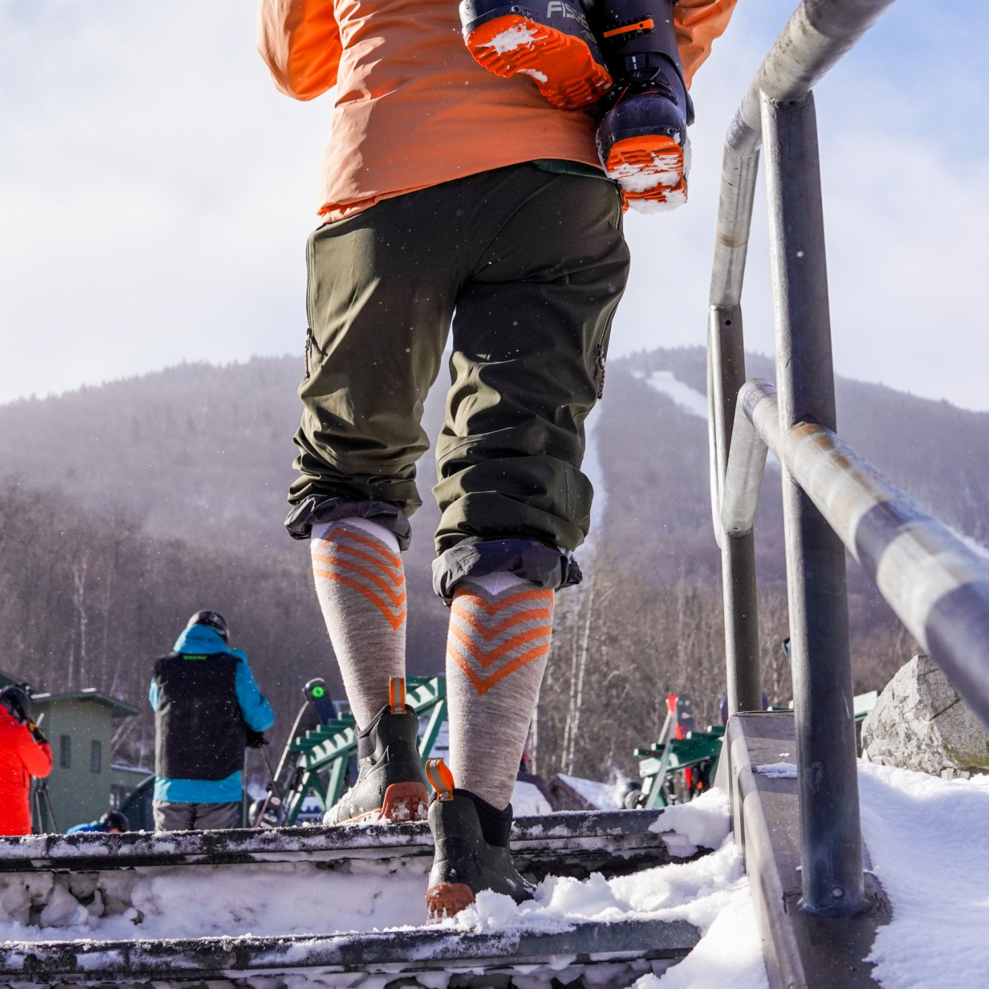 Model walk up stairs in snow wearing short boot and the 8035 Peaks RFL in Biscotti