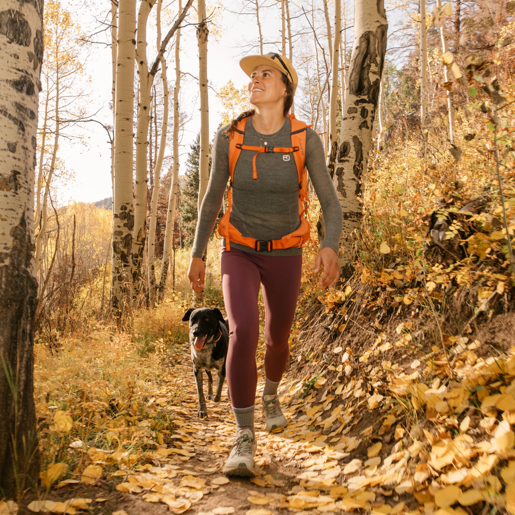 model walking through the woods with her dog wearing the 1903 micro crew hiker in light denim