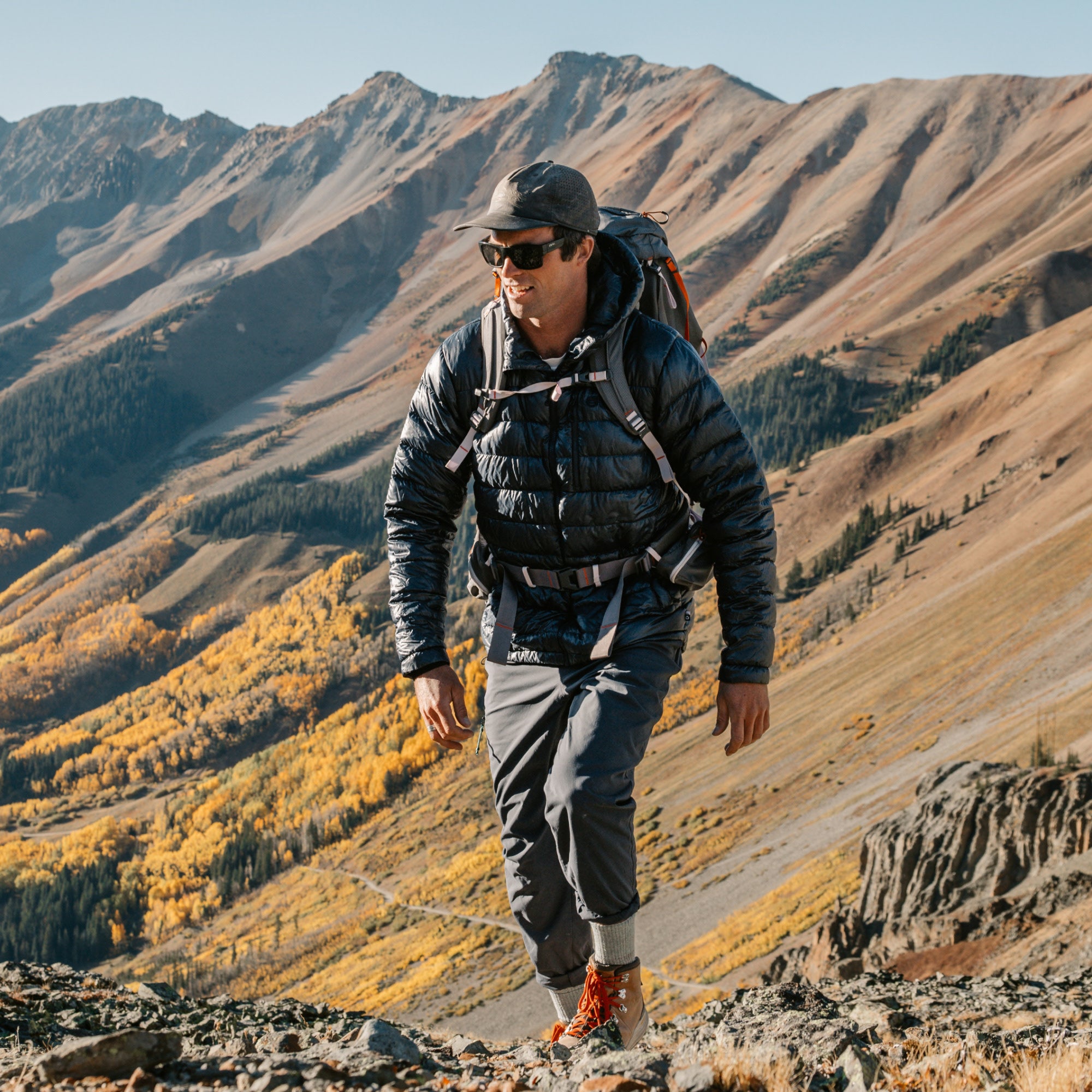 model hiking up canyon mountain side wearing the 1953 micro crew mountaineering sock in geyser