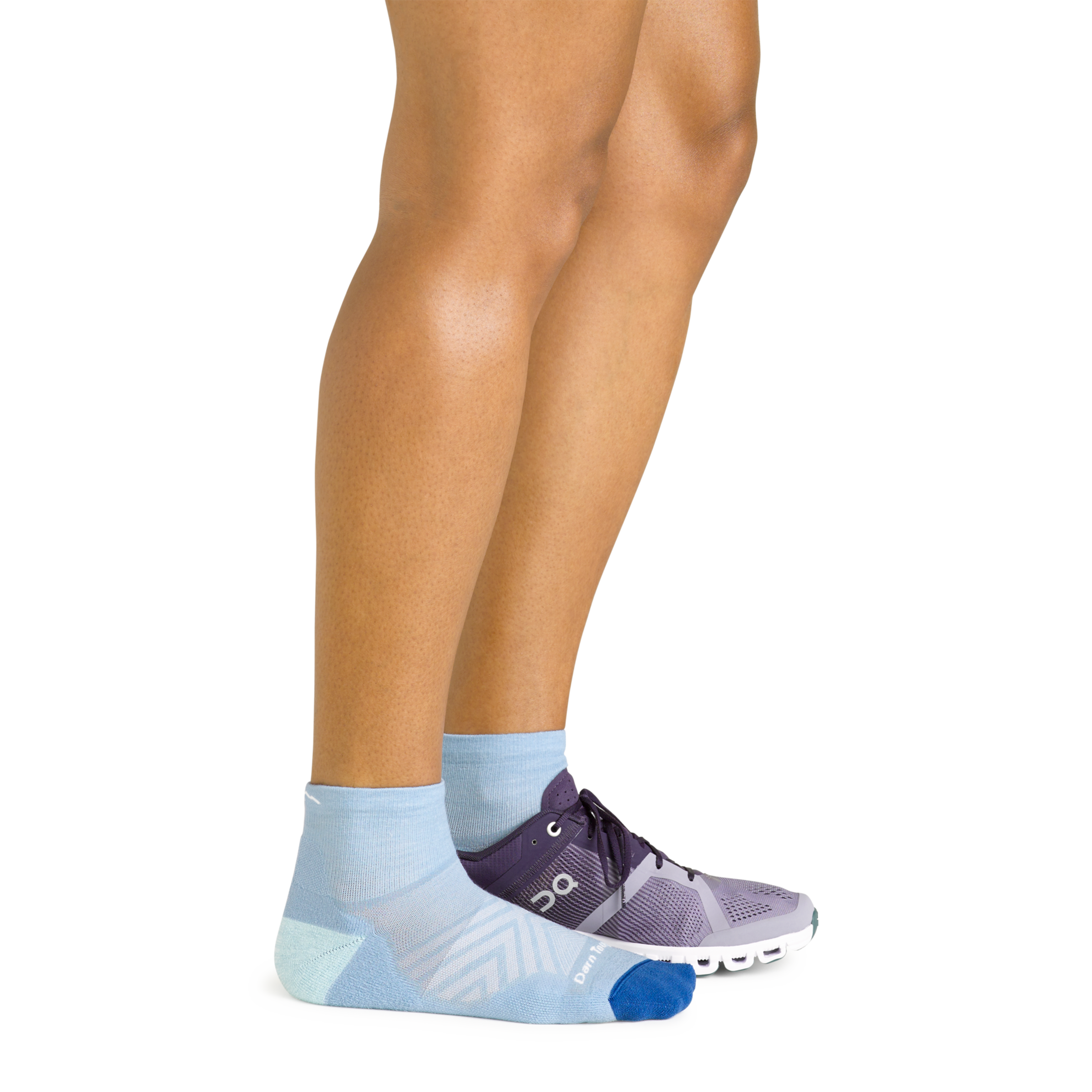 Side shot of model wearing the women's quarter running sock in sky blue with a purple sneaker on her left foot