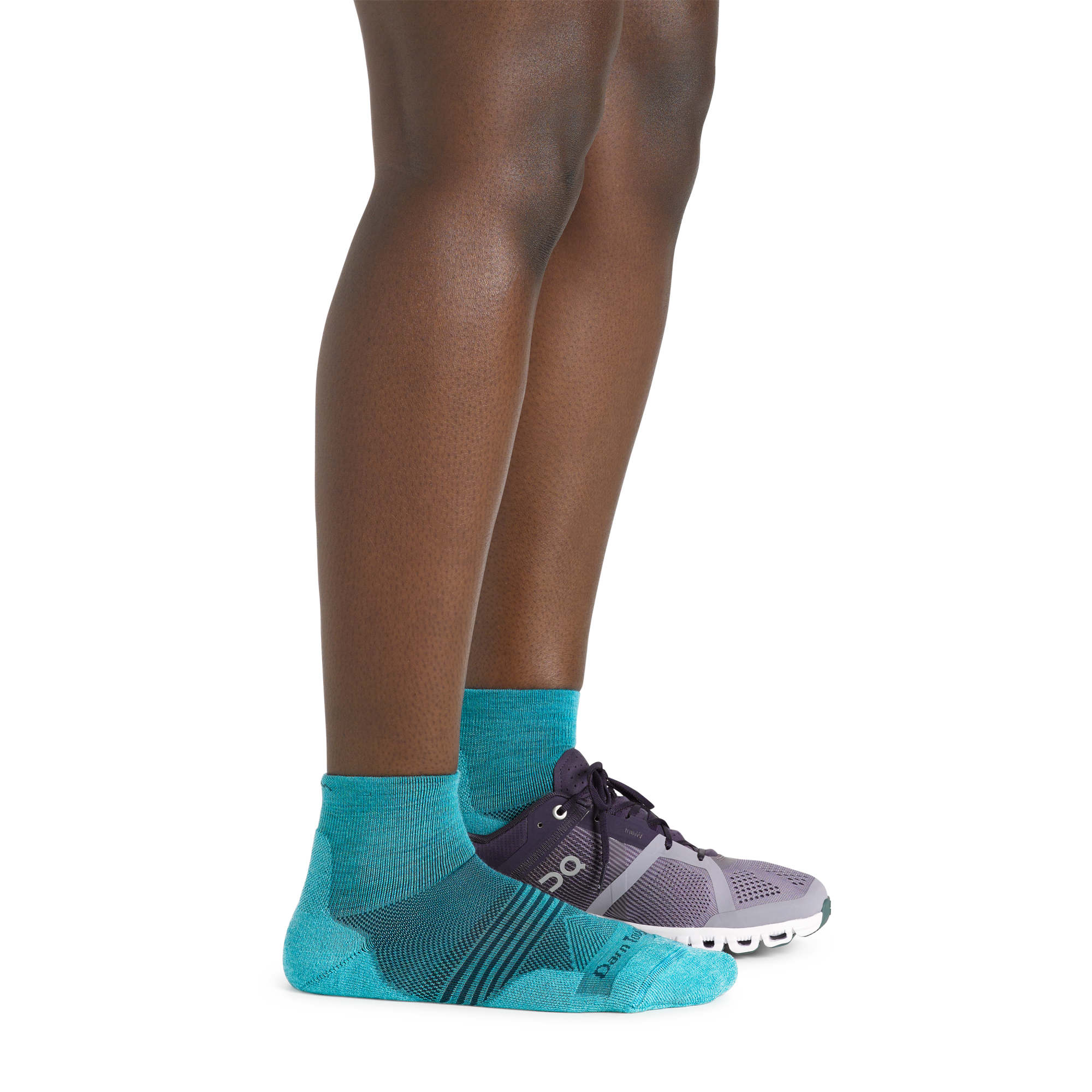 Side shot of model wearing the women's element quarter height running sock in cyan with a sneaker on her left foot