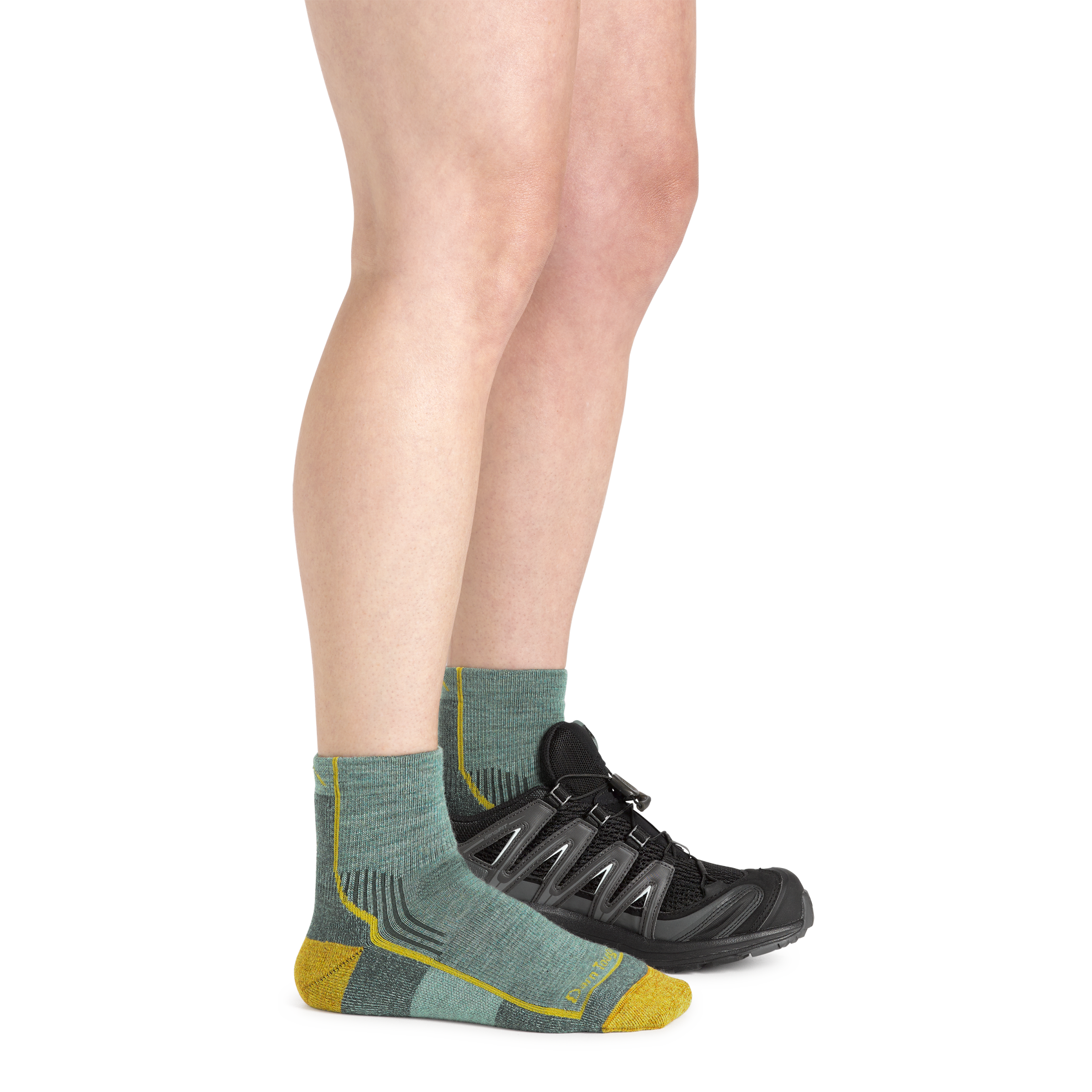 Woman wearing Women's Hiker Quarter Midweight Hiking Socks in sage and a hiking shoe on one foot