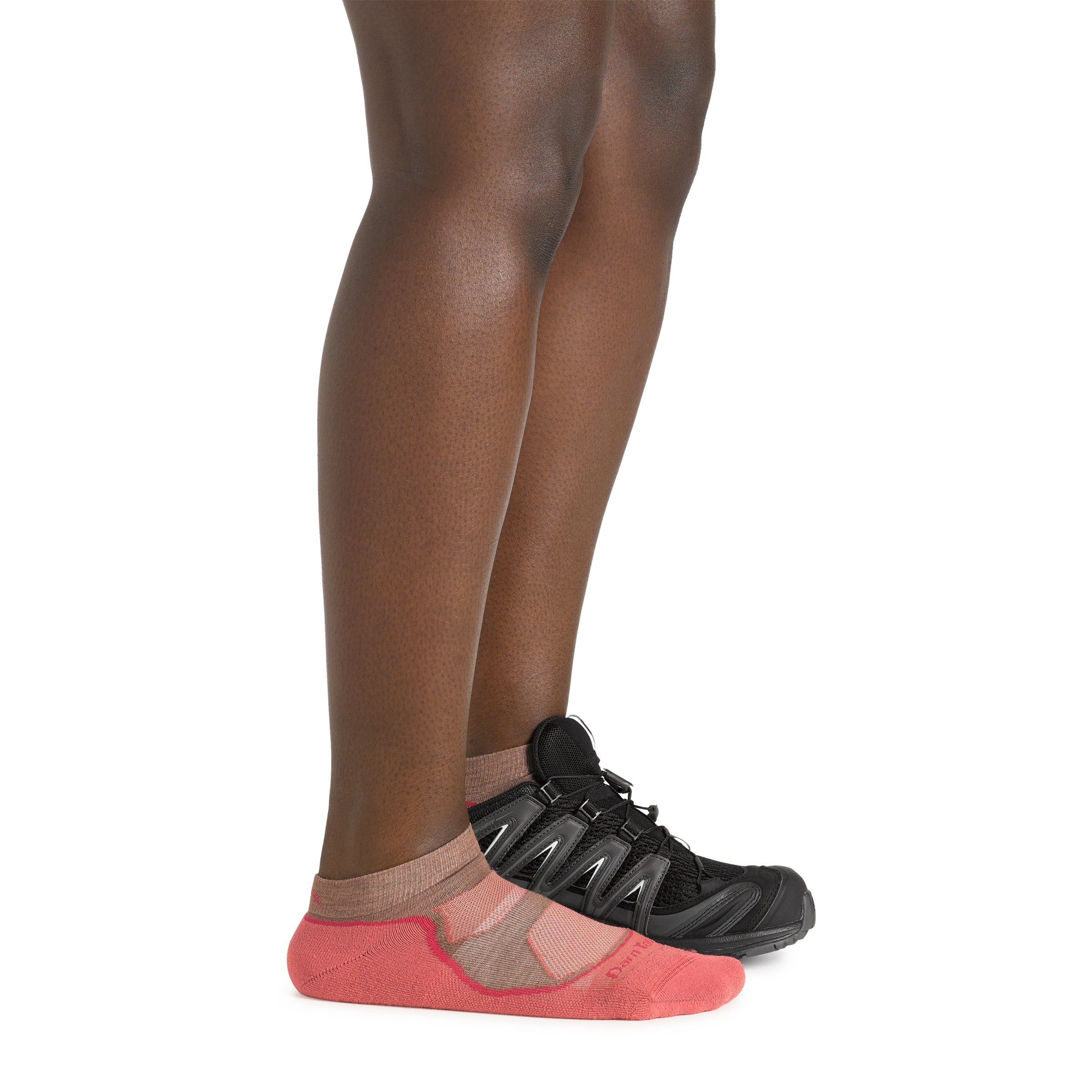 Profile image of a woman's legs on a white background, wearing Women's Light Hiker No Show Lightweight Hiking Socks in Canyon colorway, with one foot also in a hiking shoe