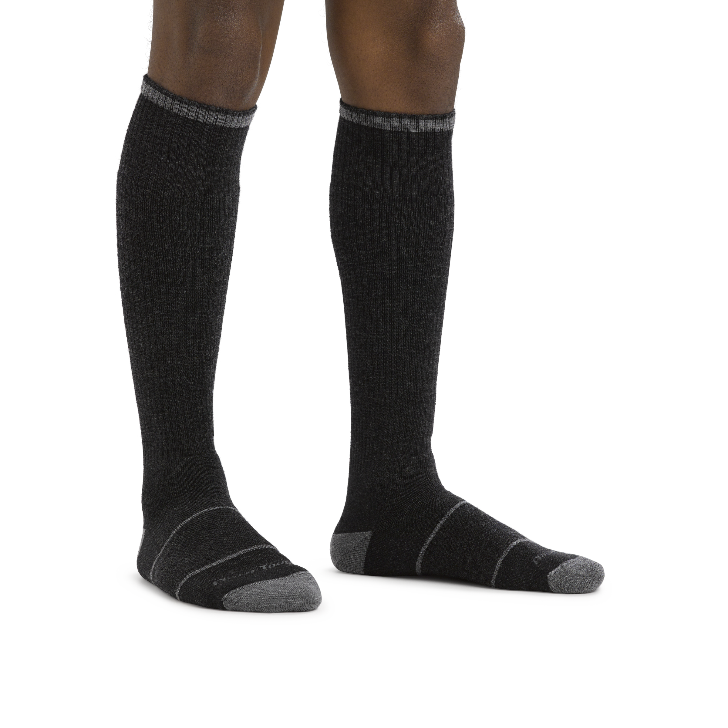 Man standing barefoot wearing Paul Bunyan Over the Calf Midweight Work Sock in Gravel