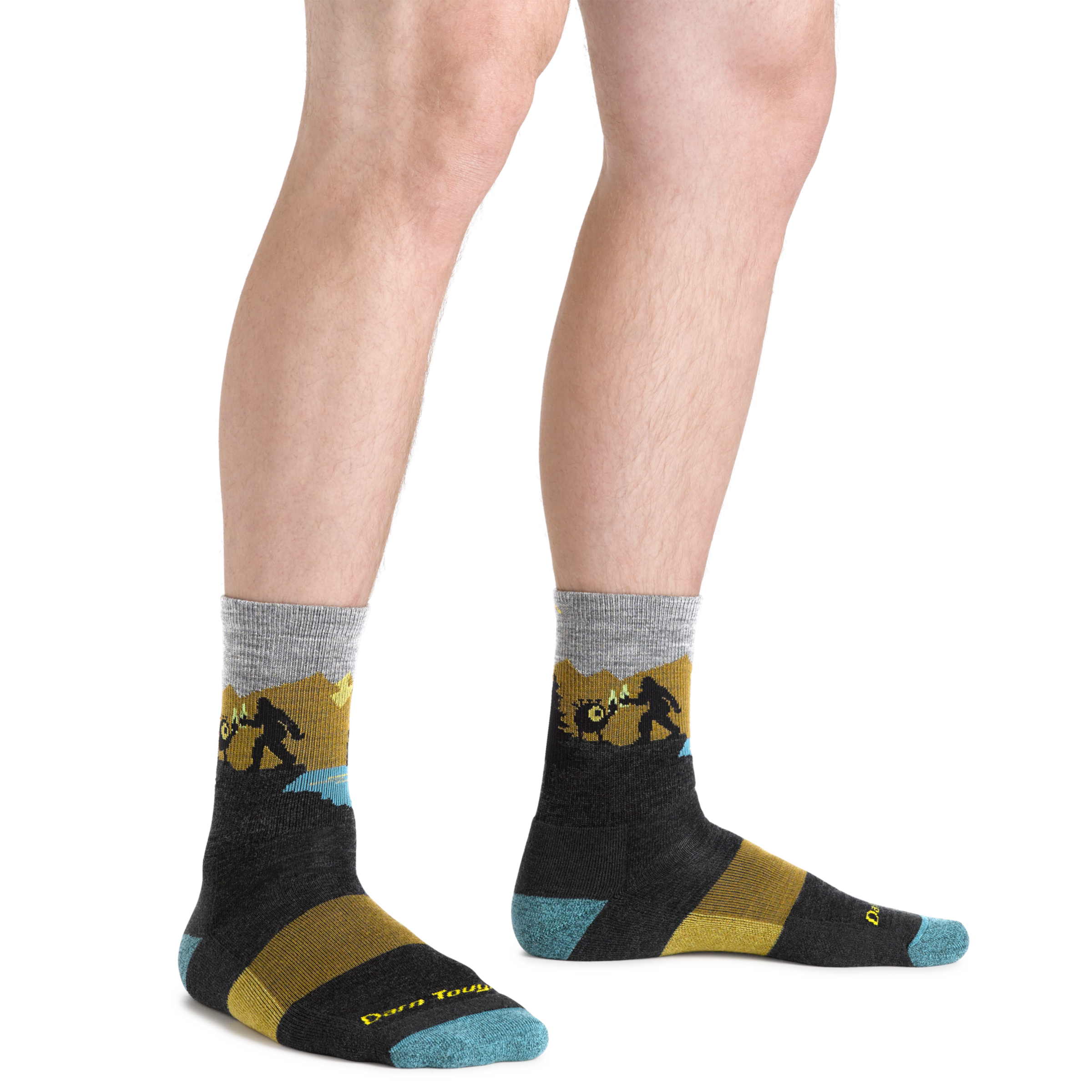 Close up shot of model wearing the men's close encounter micro crew hiking sock in charcoal with no shoes on