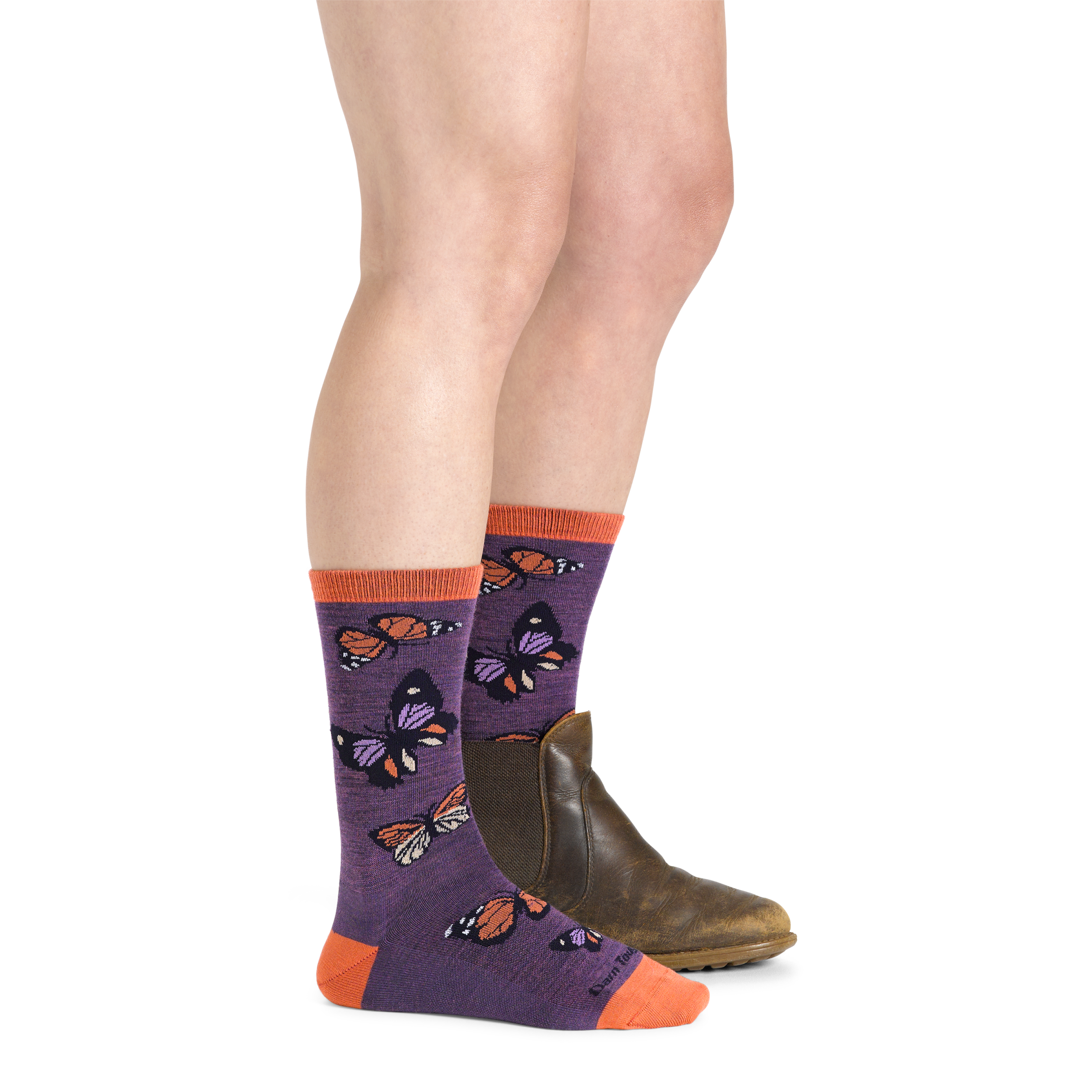 Model wearing women's flutter crew lightweight lifestyle sock in plum with brown boot on left foot