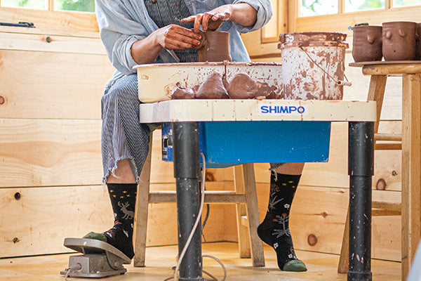 Potter working at the wheel wearing women's lifestyle socks from darn tough, great socks for dress and casual everyday wear