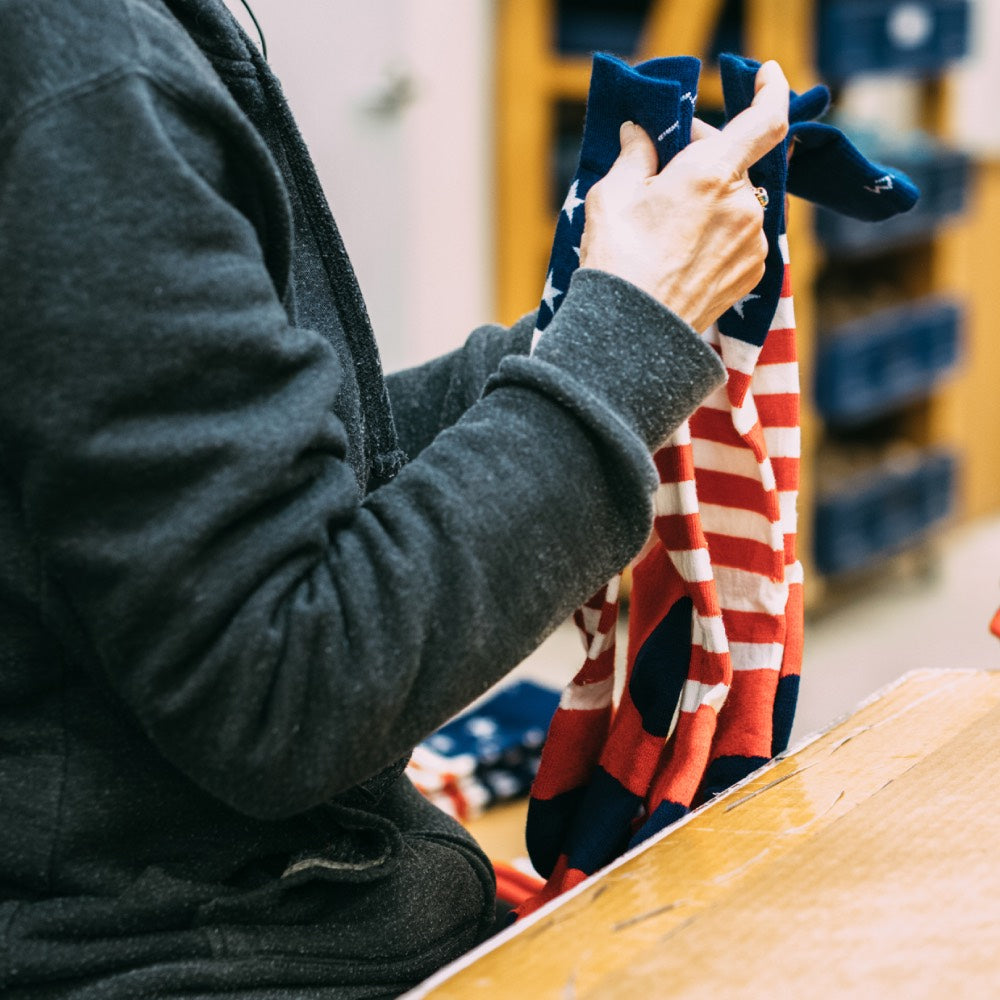 Woman at darn tough folding the Americana socks made in the USA