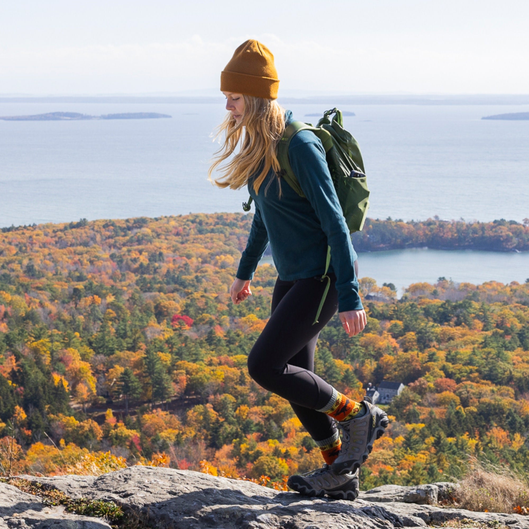 woman hiking with ocean and foliage in background wearing 5017 boot midweight with cushion moose meadow sock