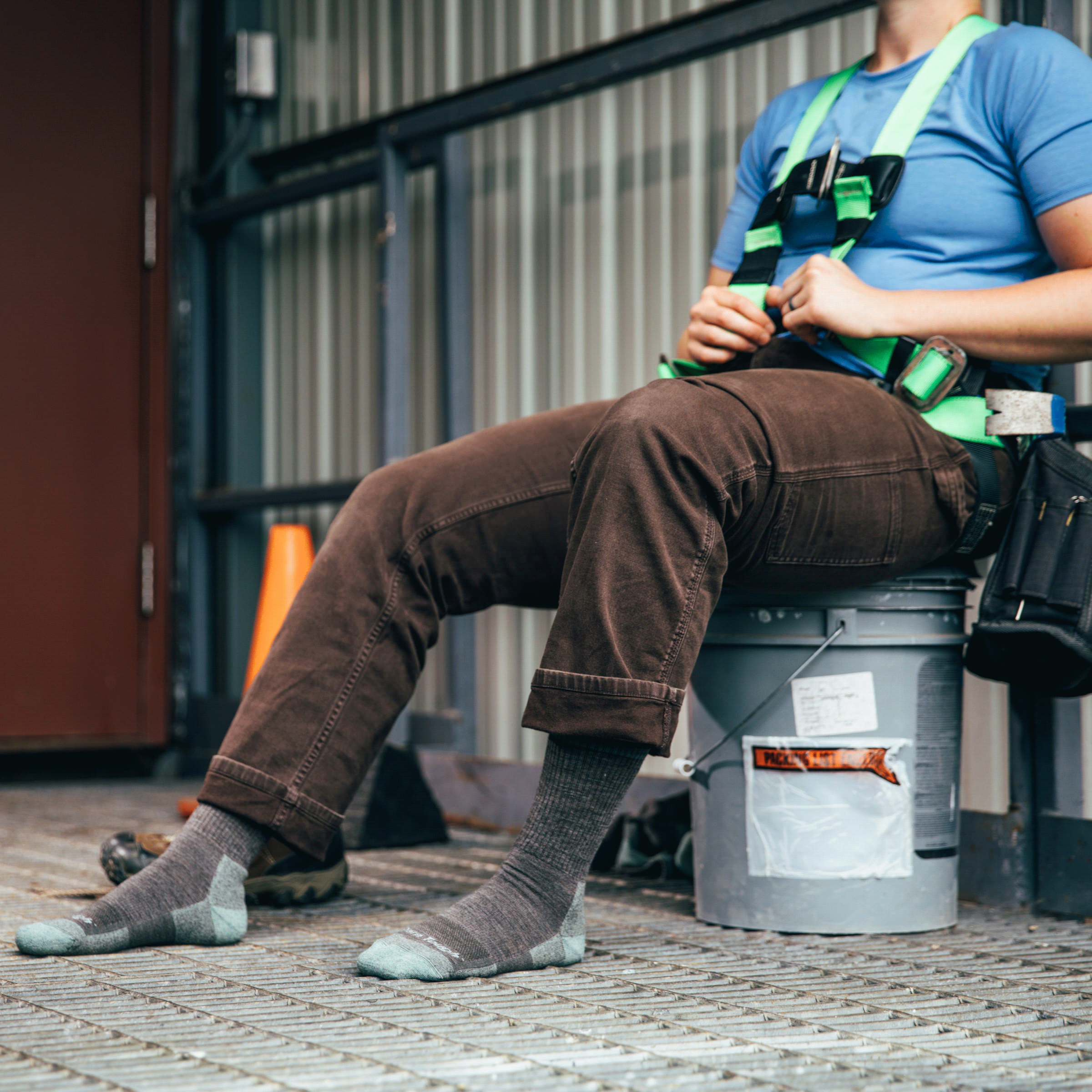 Worker seated on a break, wearing RTR work boot socks in shale