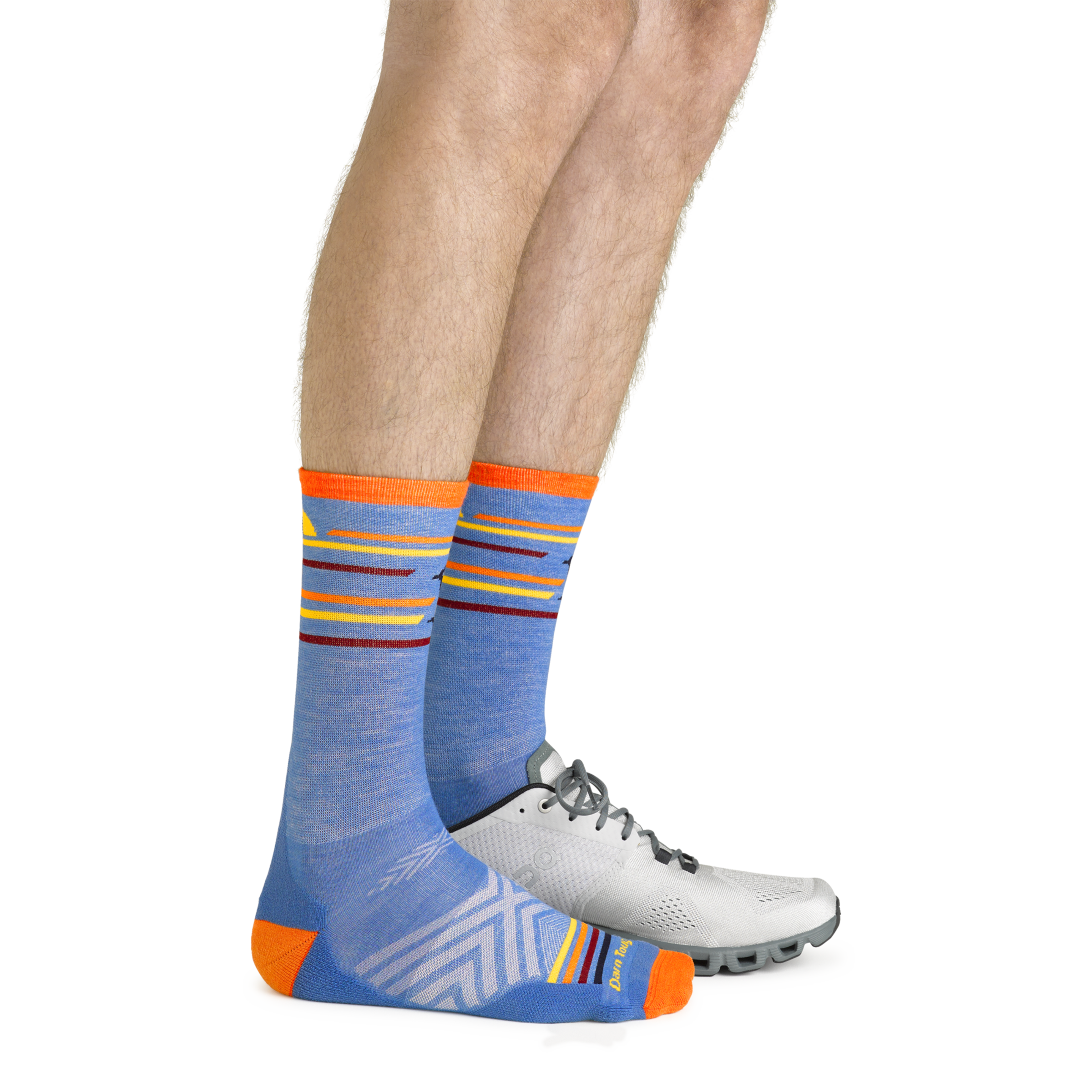 Model wearing the men's frontrunner micro crew running socks in surf blue with a white sneaker on his left foot