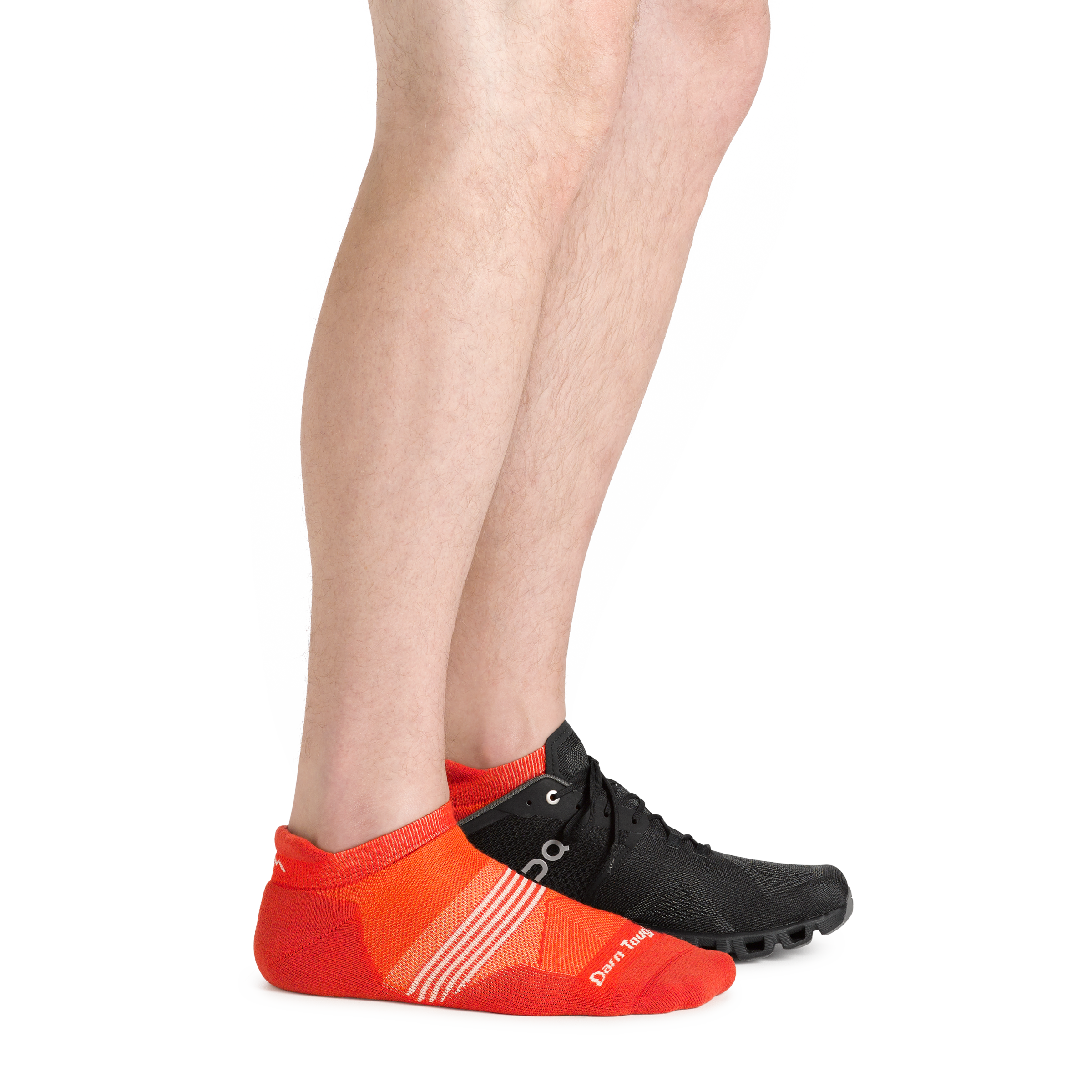 Side shot of model wearing the men's element no show tab running sock in tiger color with a black sneaker on his left foot