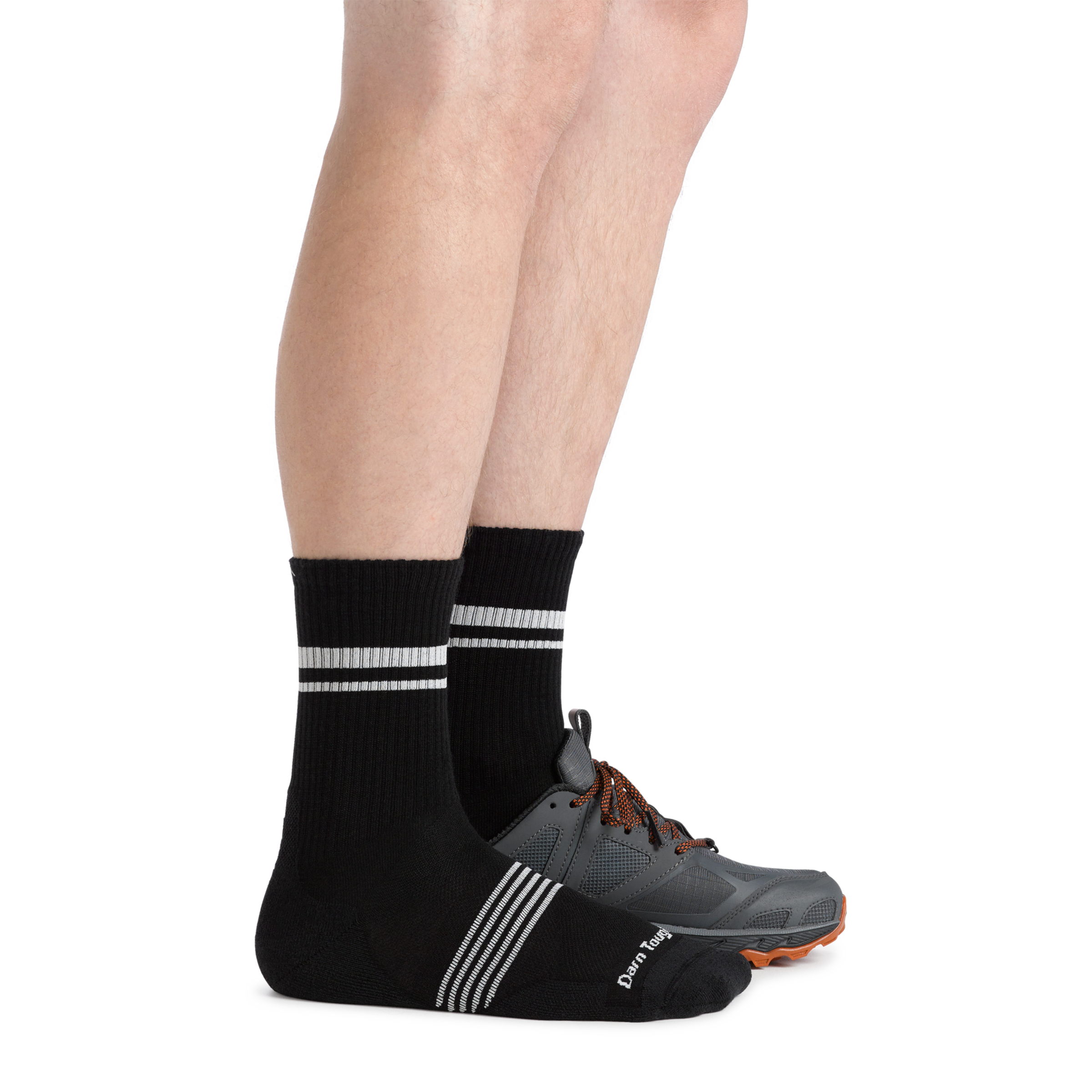 Side shot of model wearing the men's element micro crew running sock in black with a gray sneaker on his left foot