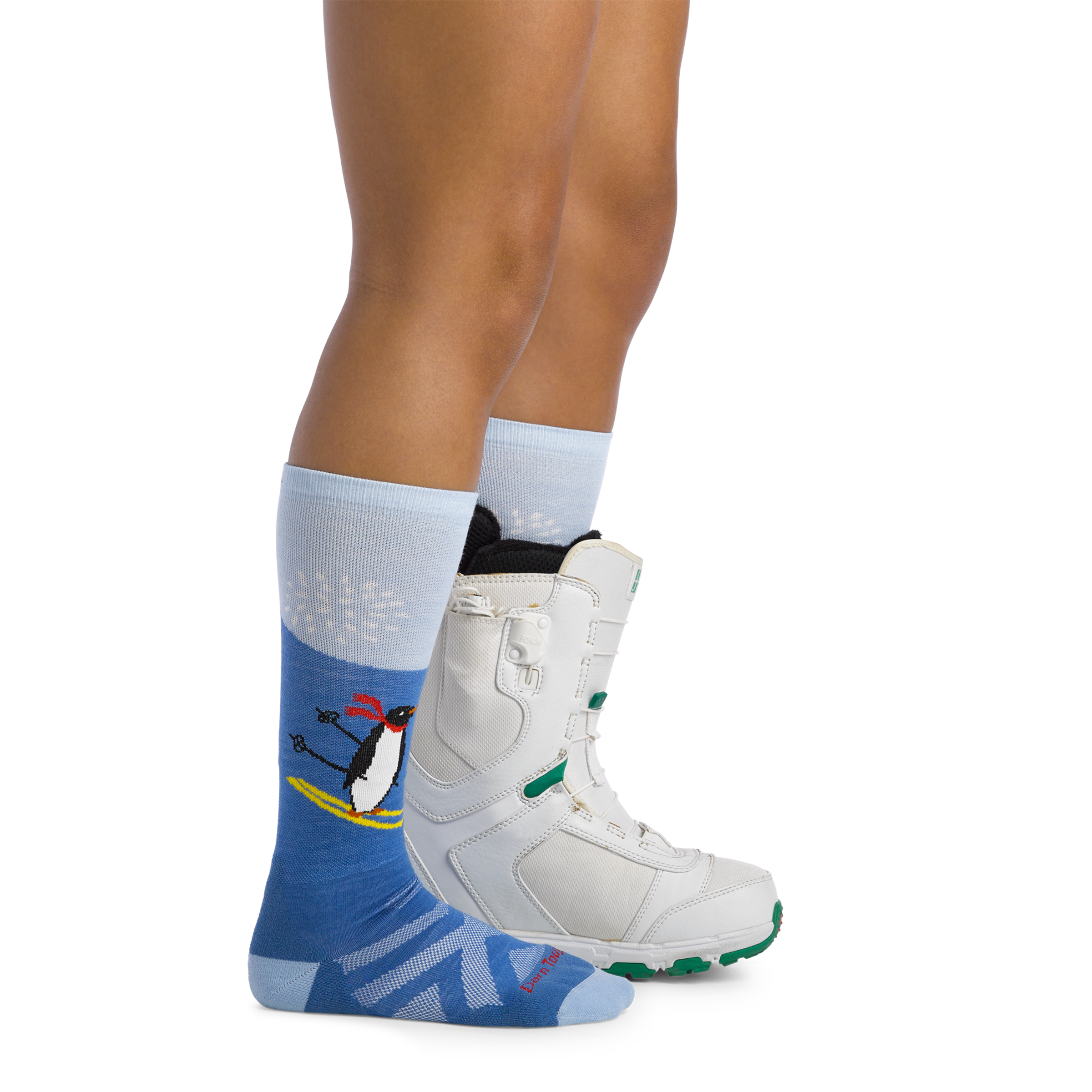 Image of model wearing 3808 Kids penguin peak ski and snowboard socks and a snow boot on one foot