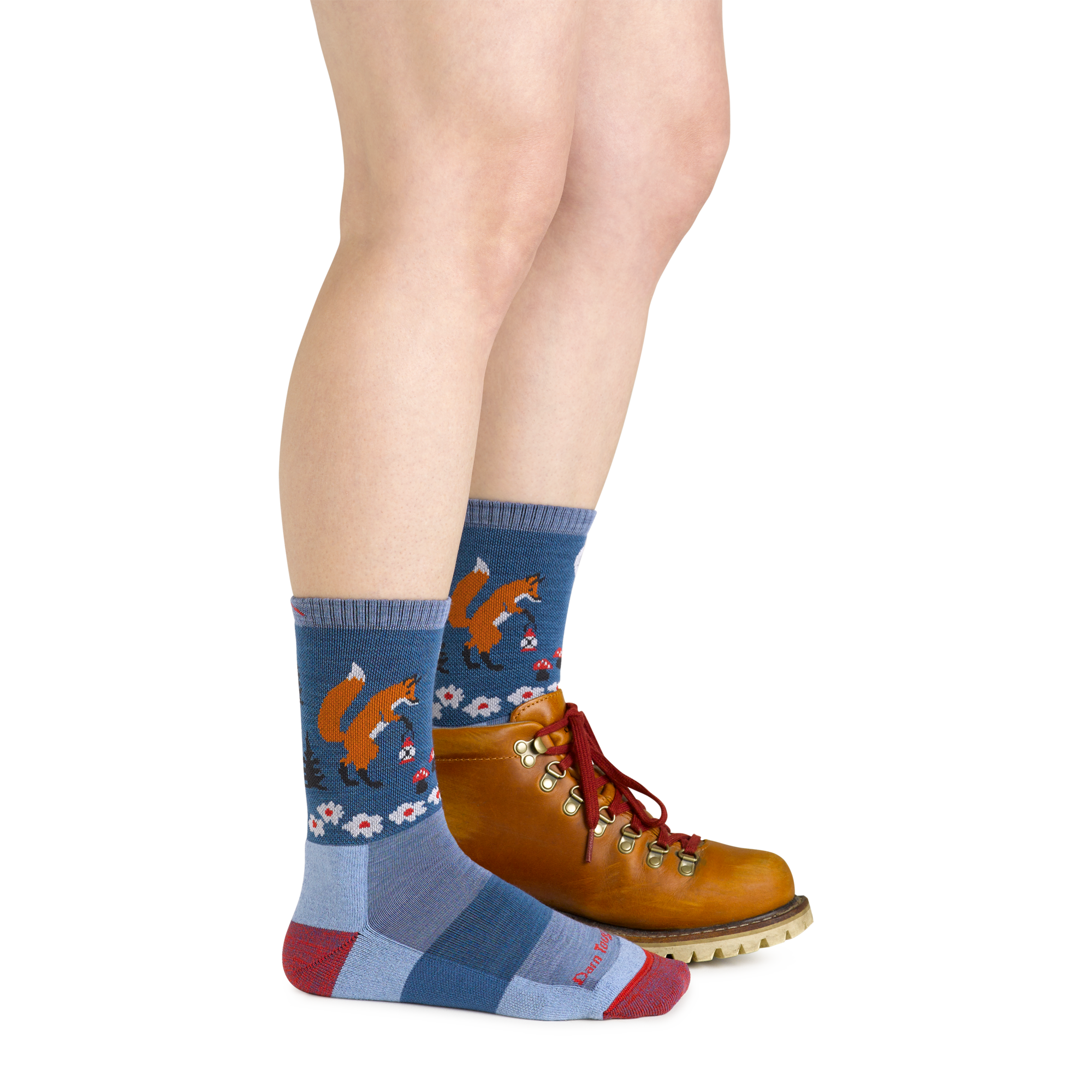 Side shot of model wearing the women's critter club micro crew hiking sock in vapor blue with a brown boot on her left foot