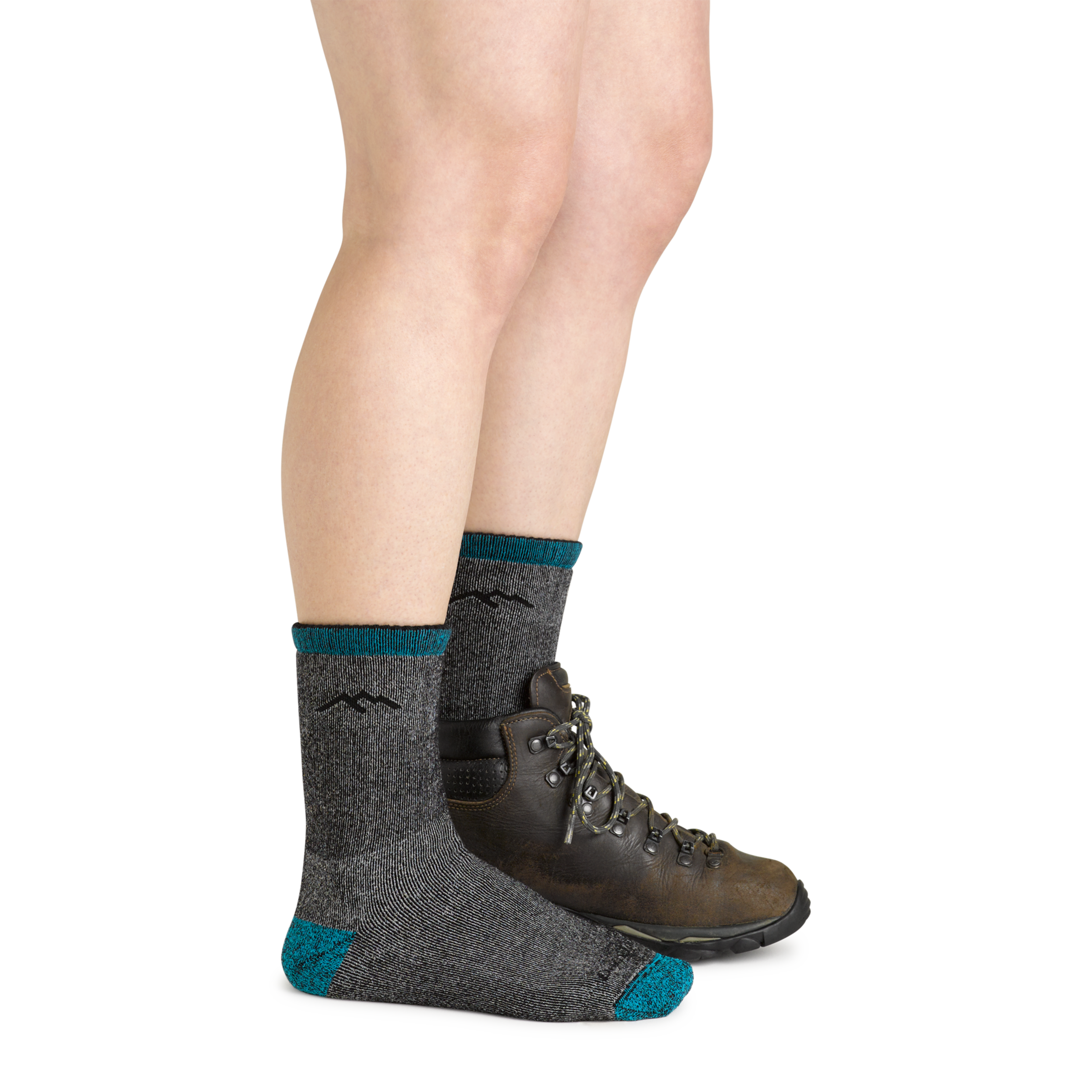 Model wearing the women's mountaineering micro crew hiking socks in midnight with a brown boot on her left foot