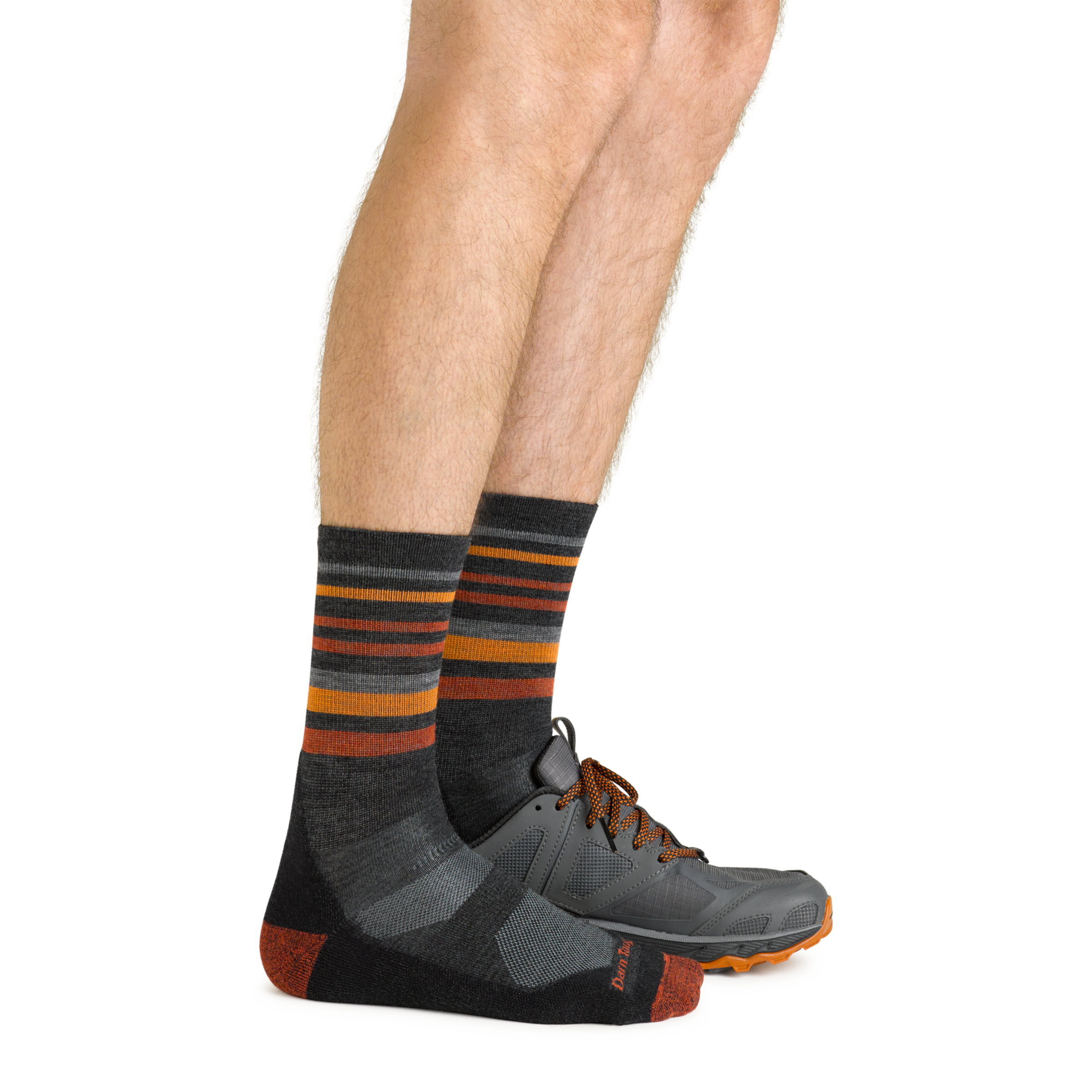 Side shot of model wearing the men's fastpack micro crew hiking socks in charcoal with a gray sneaker on his left foot