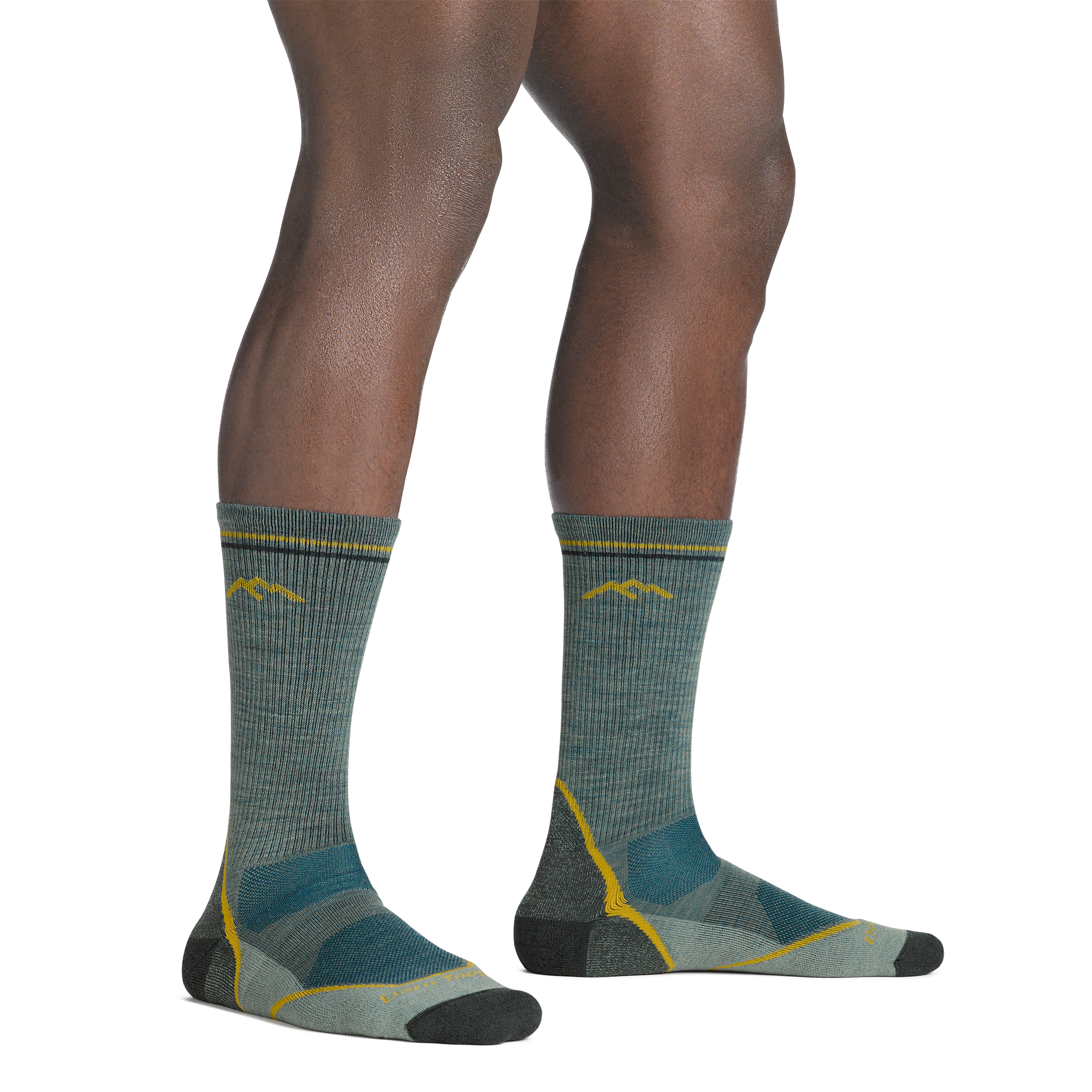 Model standing barefoot wearing the 5028 light hiker boot sock in seafoam green colorway