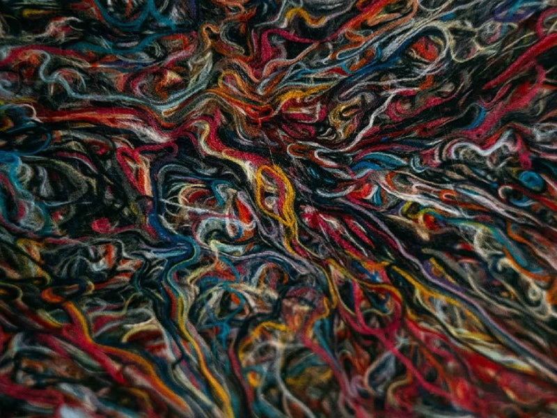 Abstract close up shot of many different colors of yarn twisted together
