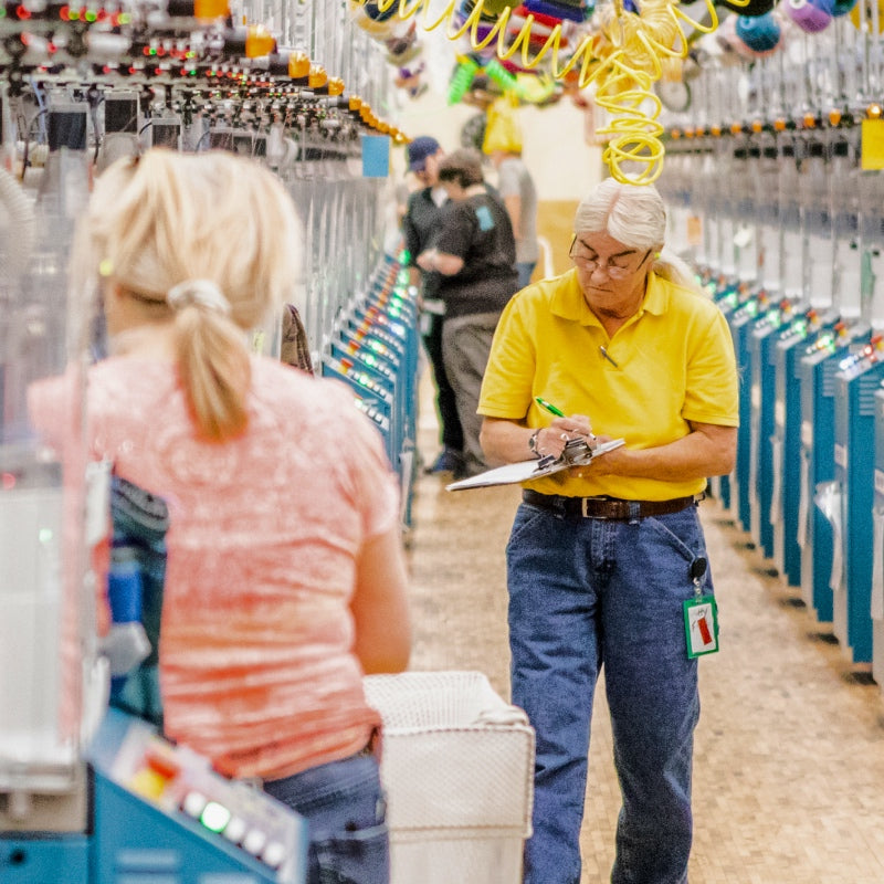 Darn Tough employees walking through the Mill, checking the machines and yarns