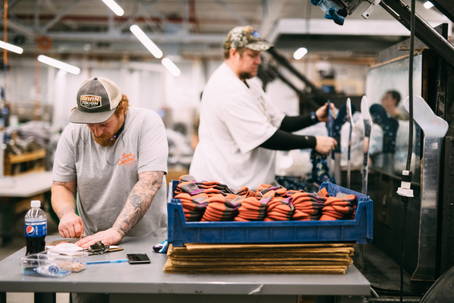 Two Darn Tough employees hard at work finishing socks