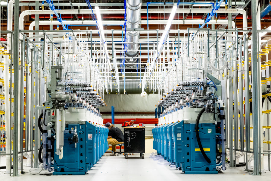 A row of brand new knitting machines getting set up at Darn Tough's 2nd Mill in Waterbury