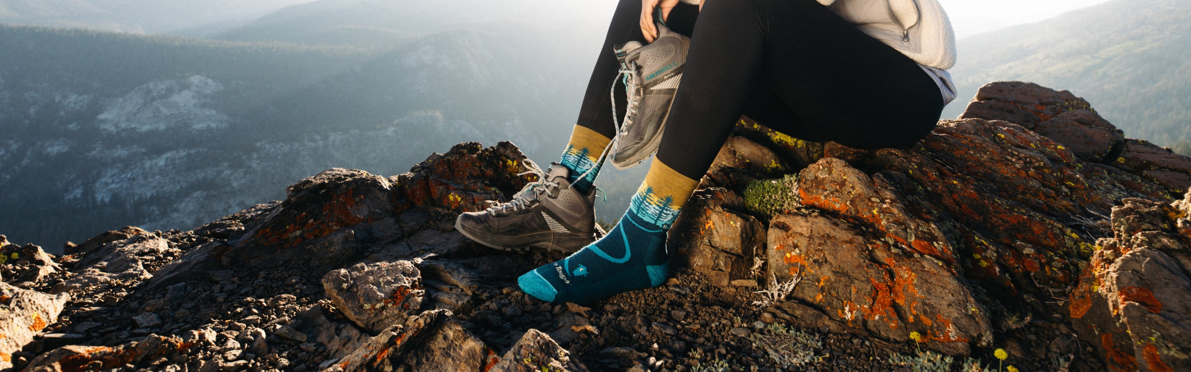 Hiker seated on a ridge line on a cold day wearing darn tough hiking socks