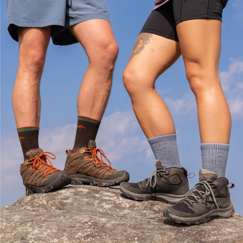 Two hikers standing on summit wearing Darn Tough hiking socks