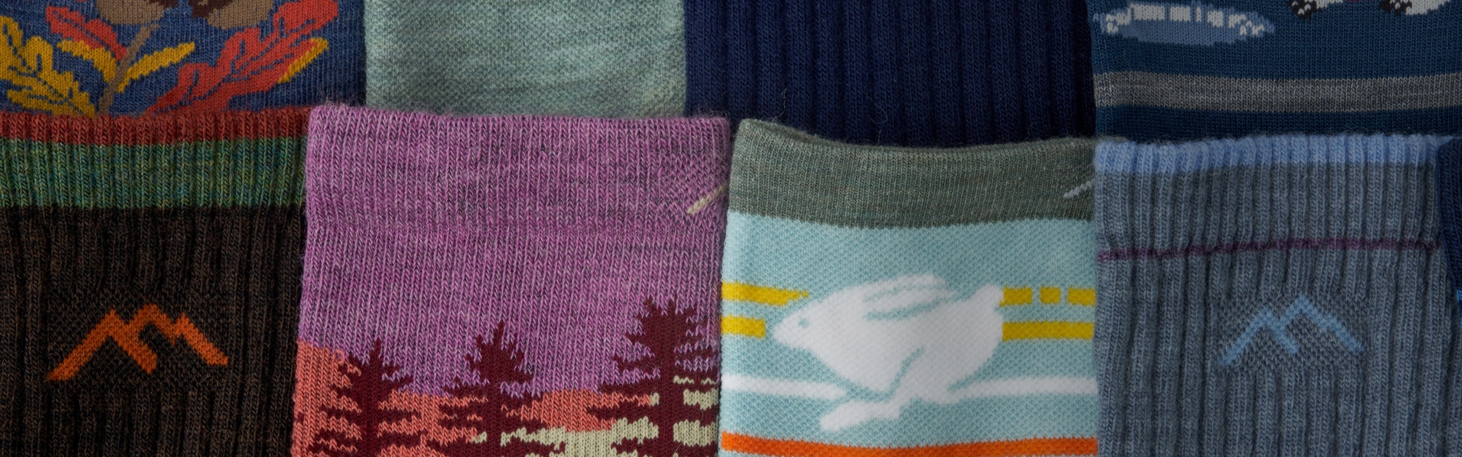 A row of Darn Tough socks in new colors laid out to show the patterns