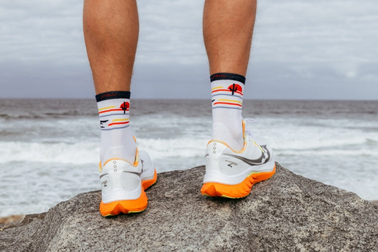Shop Run Socks - feet by the sea wearing running sneakers and darn tough run socks